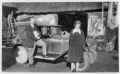 Two people by a car in the wheelwright's workshop