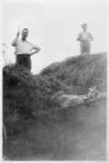 Men stacking hay or straw